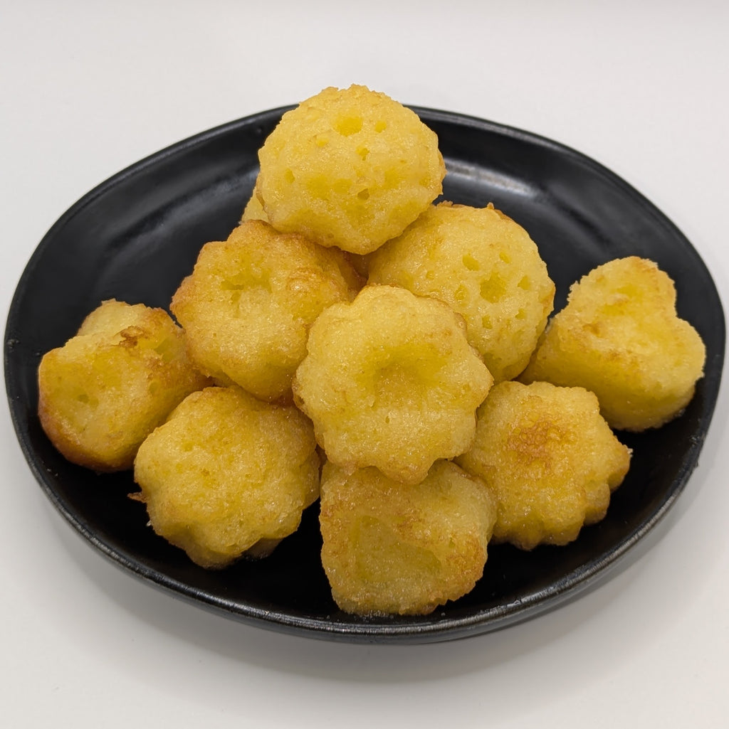 A pile of peach bellini cake bites sitting on a black plate