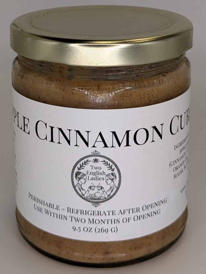 Jar of apple cinnamon curd with a gold lid on a white background