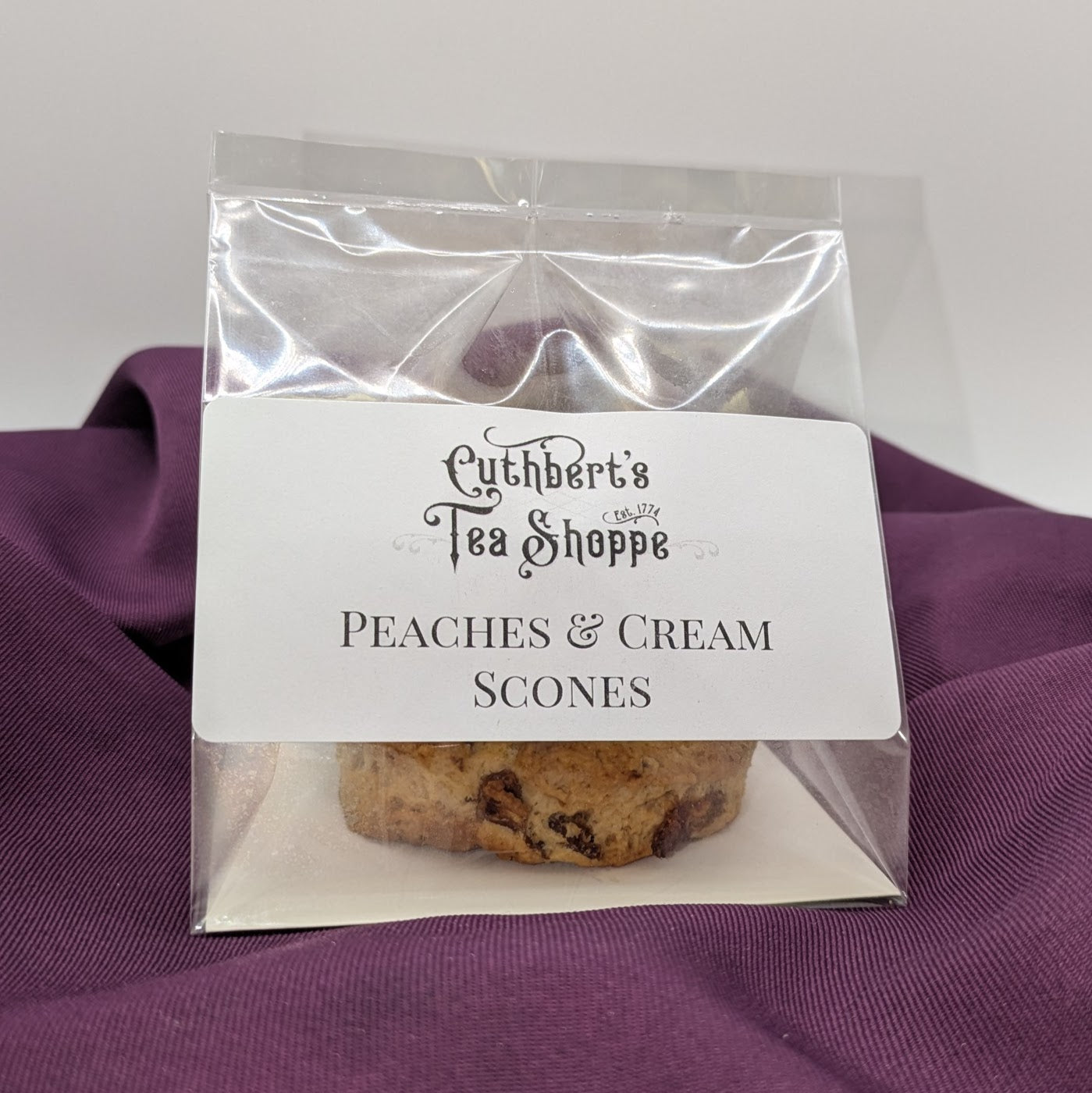 A package of peaches and cream scones sitting on purple fabric