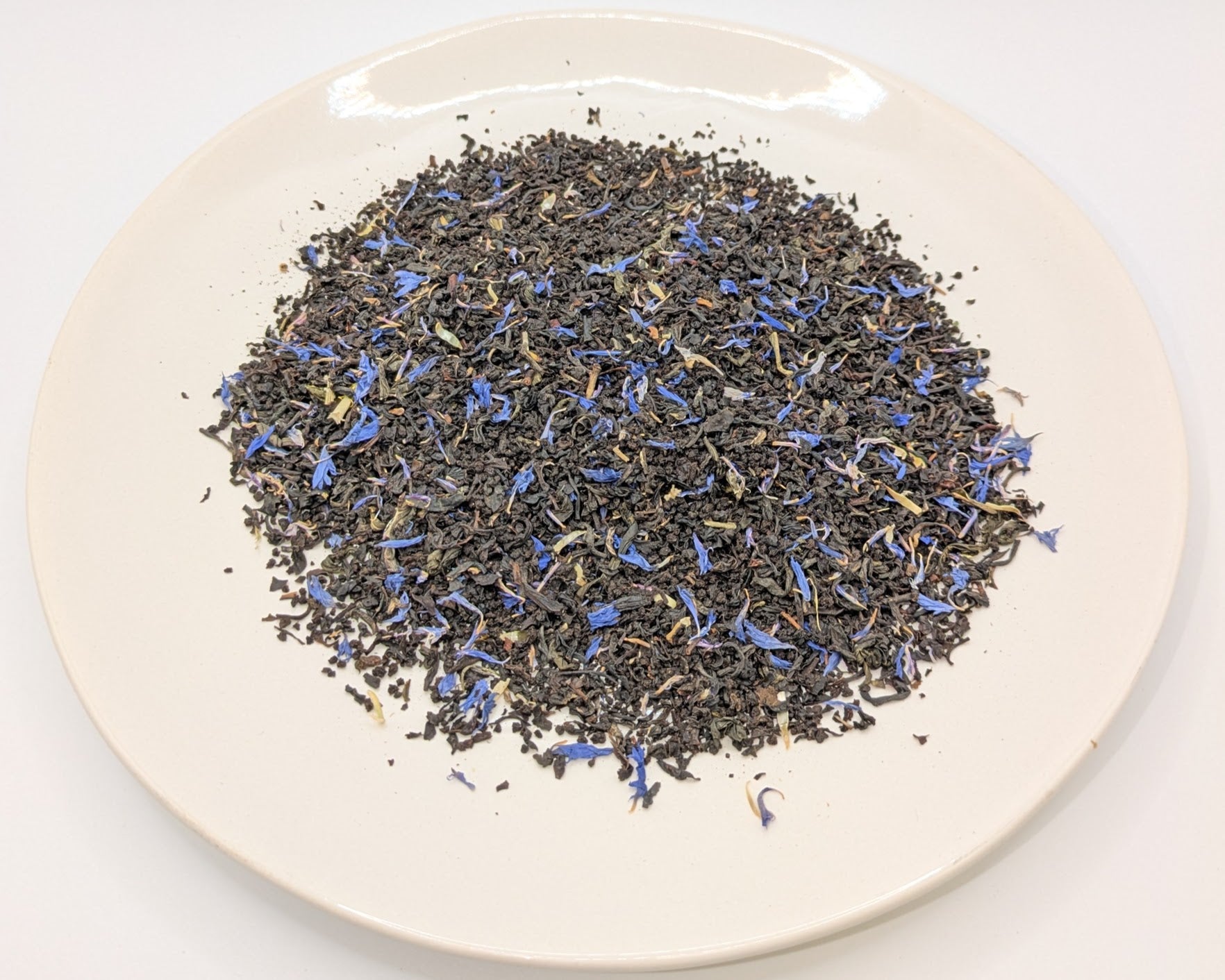 A scoop of Buckingham Palace Garden Party tea on a white plate