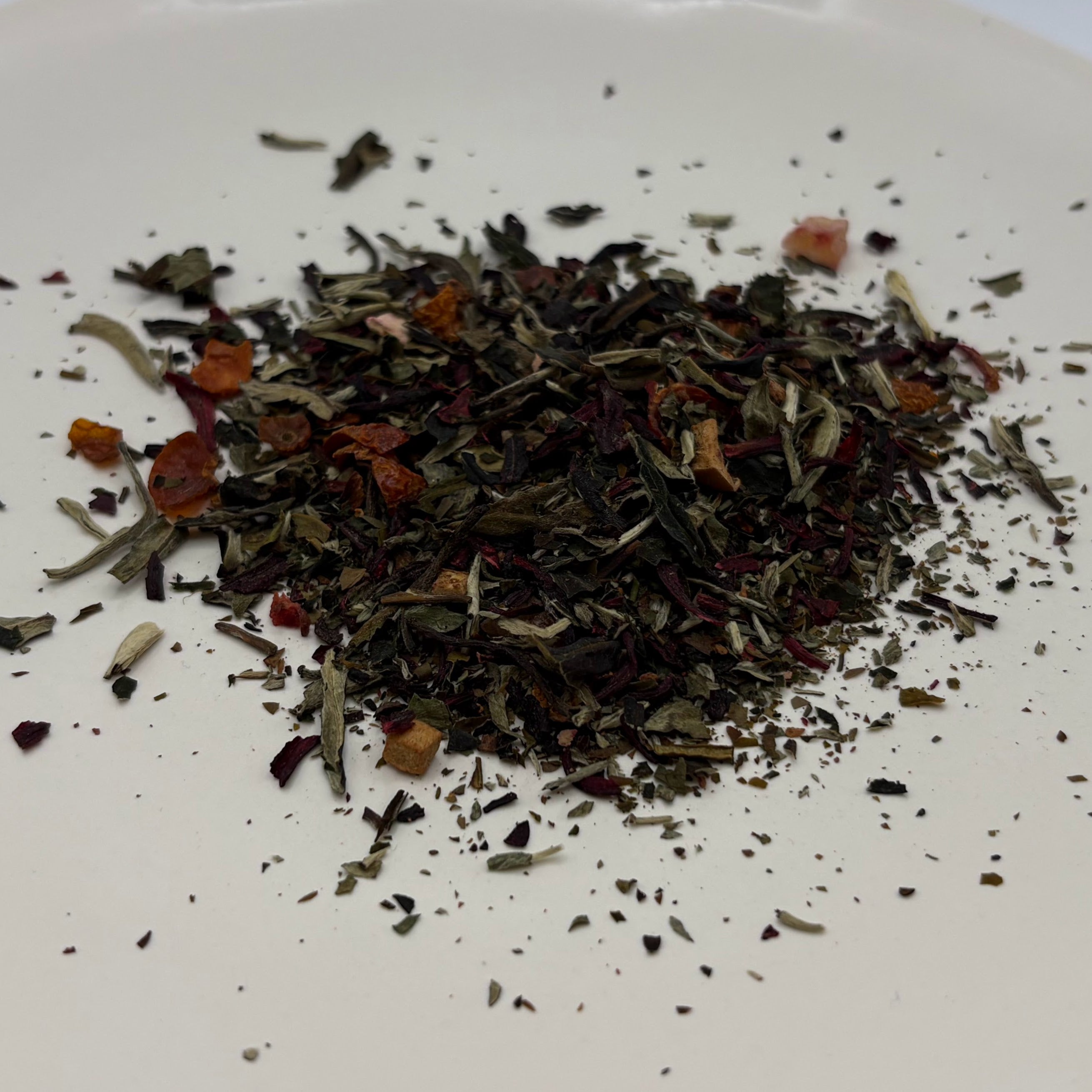 A scoop of Edwina's Peaches tea on a white background
