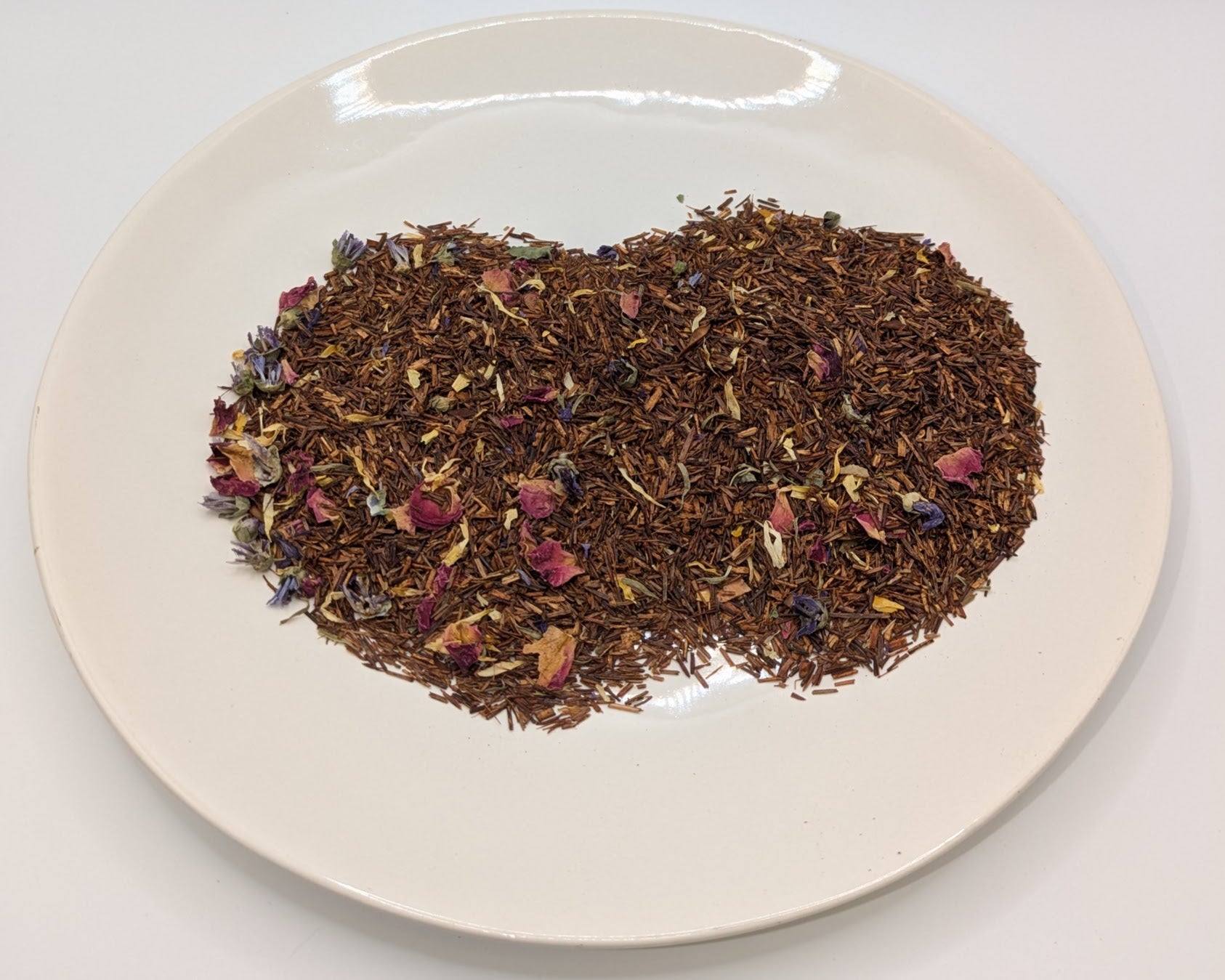 A scoop of holly berry rooibos tea on a white plate
