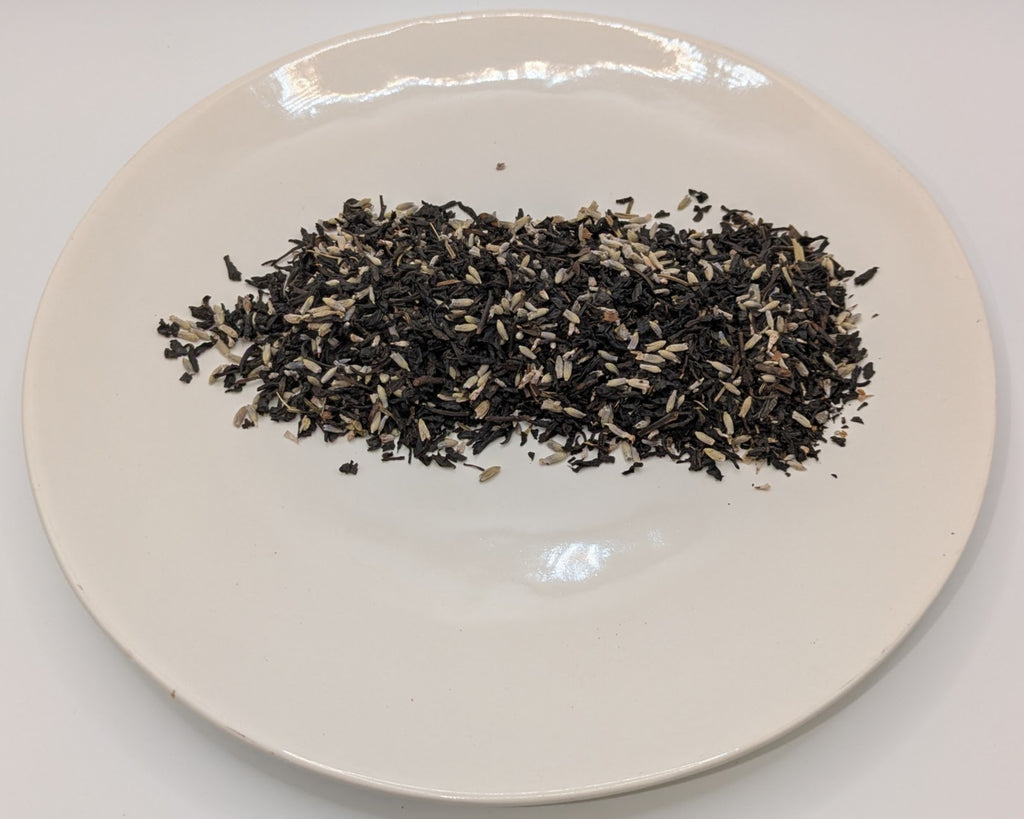 A scoop of lavender grey tea on a white plate