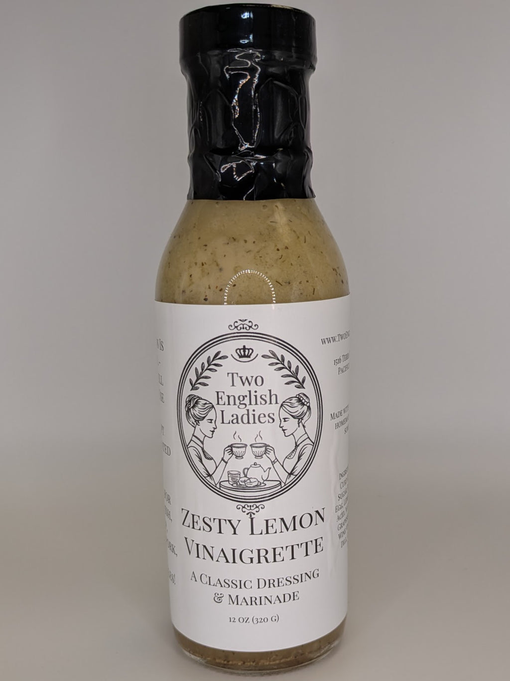 Bottle of Two English Ladies zesty lemon vinaigrette on a white background