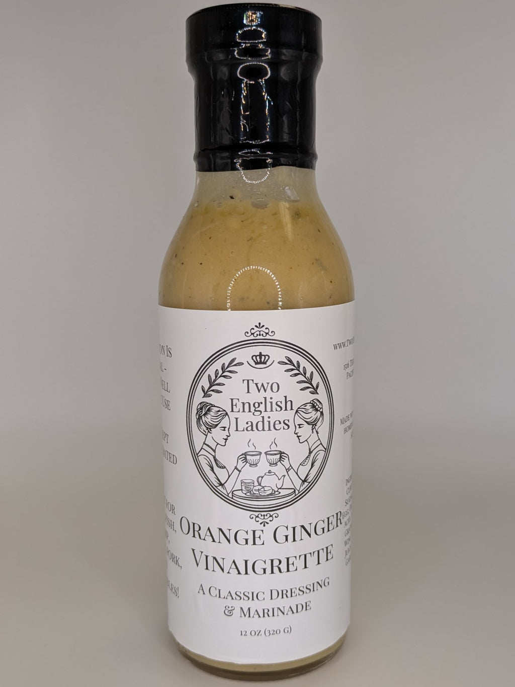 Bottle of Two English Ladies orange ginger vinaigrette on a white background